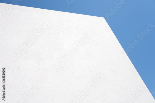 Textured White concrete background on blue sky background. Wall white painted. Mock up
