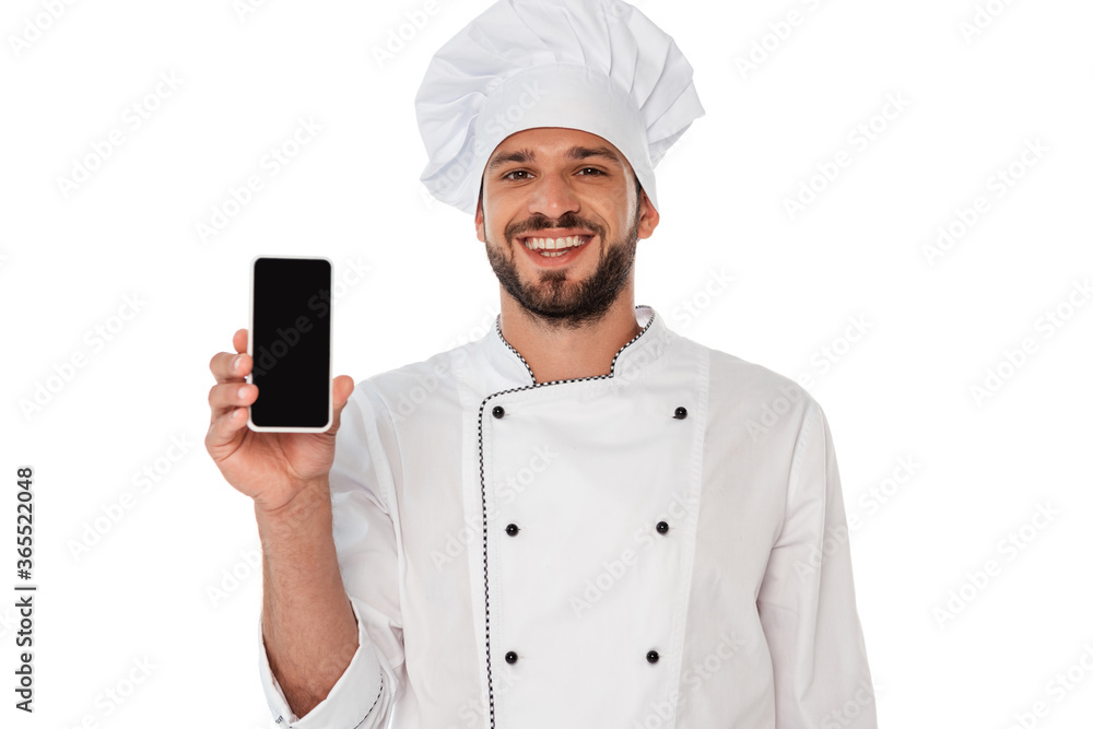 Smiling chef in uniform showing smartphone with blank screen isolated on white Smiling chef in uniform showing smartphone with blank screen isolated on white
