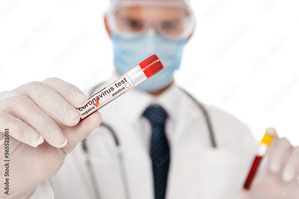 Selective focus of doctor in medical mask showing test tube with blood sample and coronavirus lettering isolated on white Selective focus of doctor in medical mask showing test tube with blood sample and coronavirus lettering isolated on white