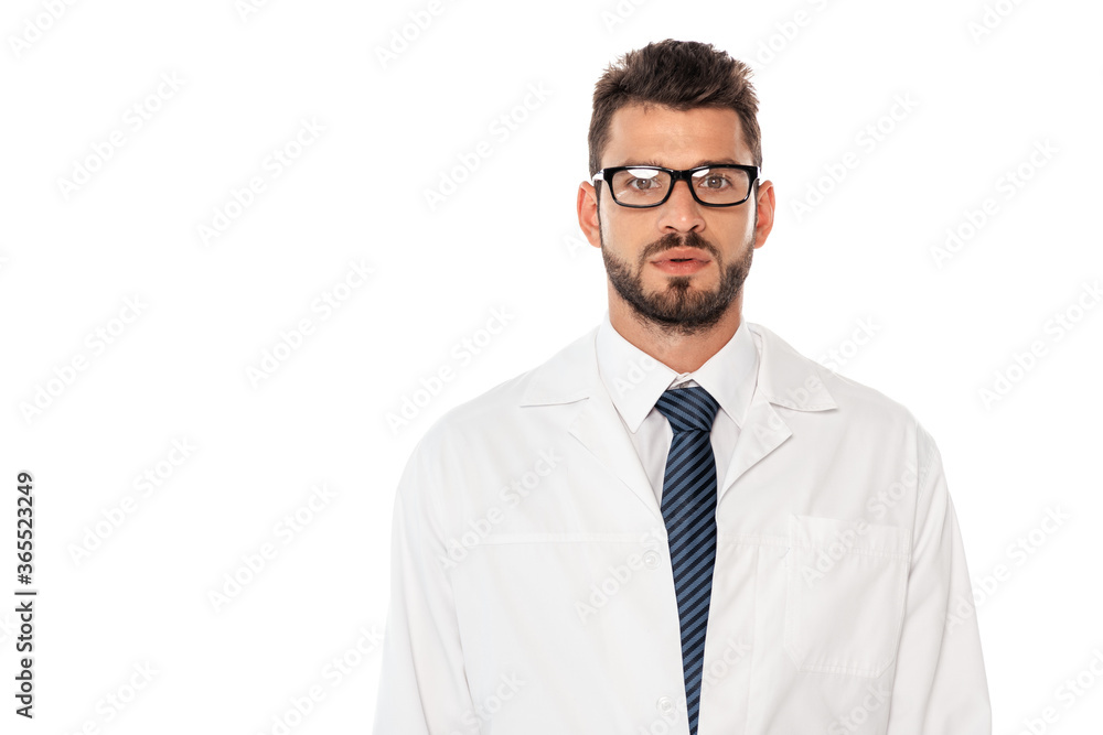 Handsome bearded doctor in white coat and eyeglasses looking at camera isolated on white Handsome bearded doctor in white coat and eyeglasses looking at camera isolated on white