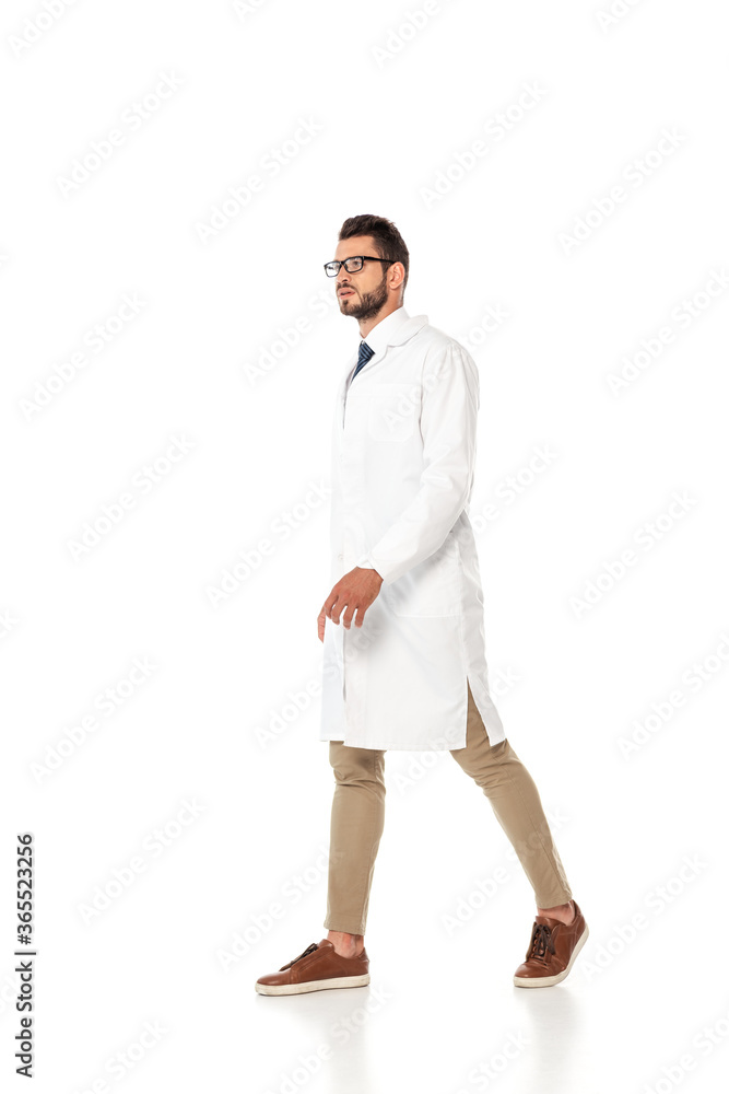 Doctor in white coat and eyeglasses walking on white background