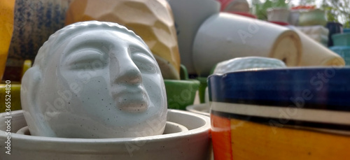 Buddha face as a garden porcelain pot in a nursery