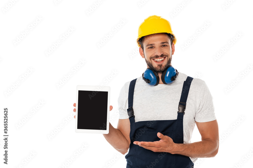 Smiling manual worker pointing with hand at digital tablet with blank screen isolated on white Smiling manual worker pointing with hand at digital tablet with blank screen isolated on white