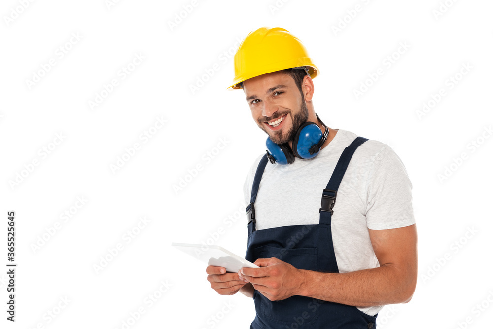 Handsome manual worker smiling at camera and holding digital tablet isolated on white Handsome manual worker smiling at camera and holding digital tablet isolated on white