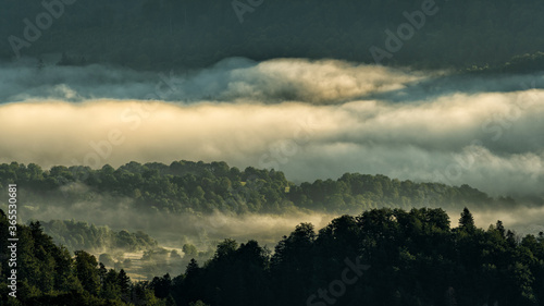 Fototapeta Naklejka Na Ścianę i Meble -  A hazy sunrise in the mountains. Mountains silhouettes and fog in the valleys. Photo from Polonina Wetlinska. Bieszczady National Park. Carpathians. Poland.