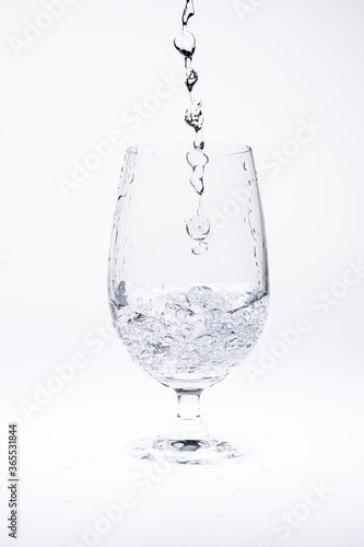 Pour water in glass isolated on white background.