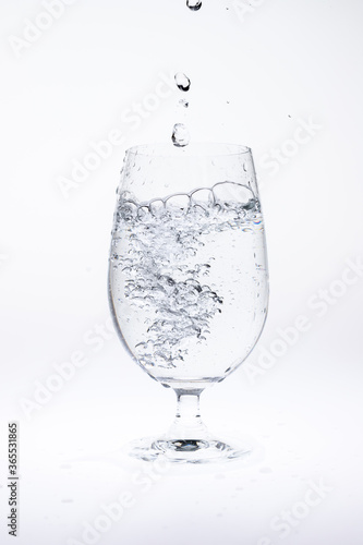 Pour water in glass isolated on white background.