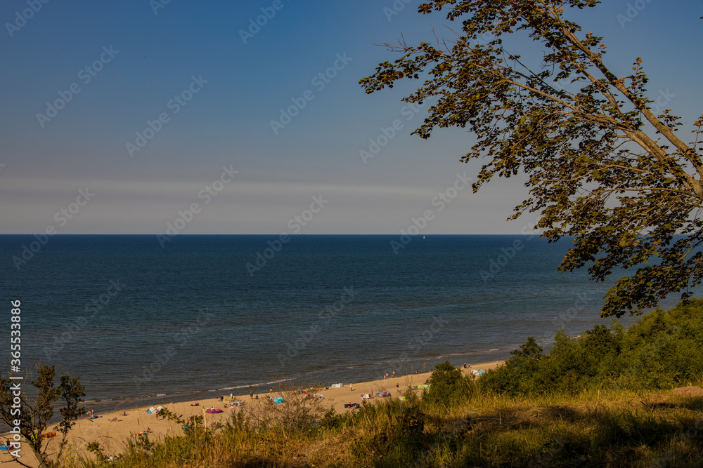 view from the escarpment to the beach on the Baltic Sea on a summer day with people view from the escarpment to the beach on the Baltic Sea on a summer day with people
