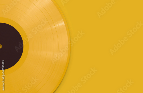 Photography Yellow Vinyl Record with a Black Label on a Flat Yellow Surface