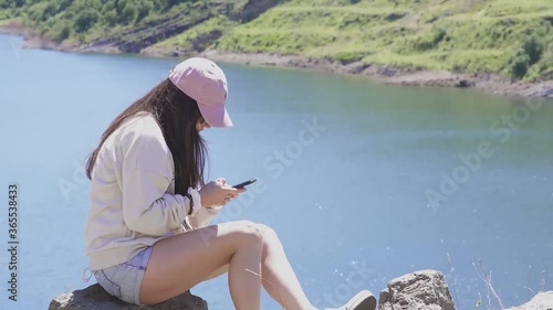  Long-haired girl by a lake enjoying the view.