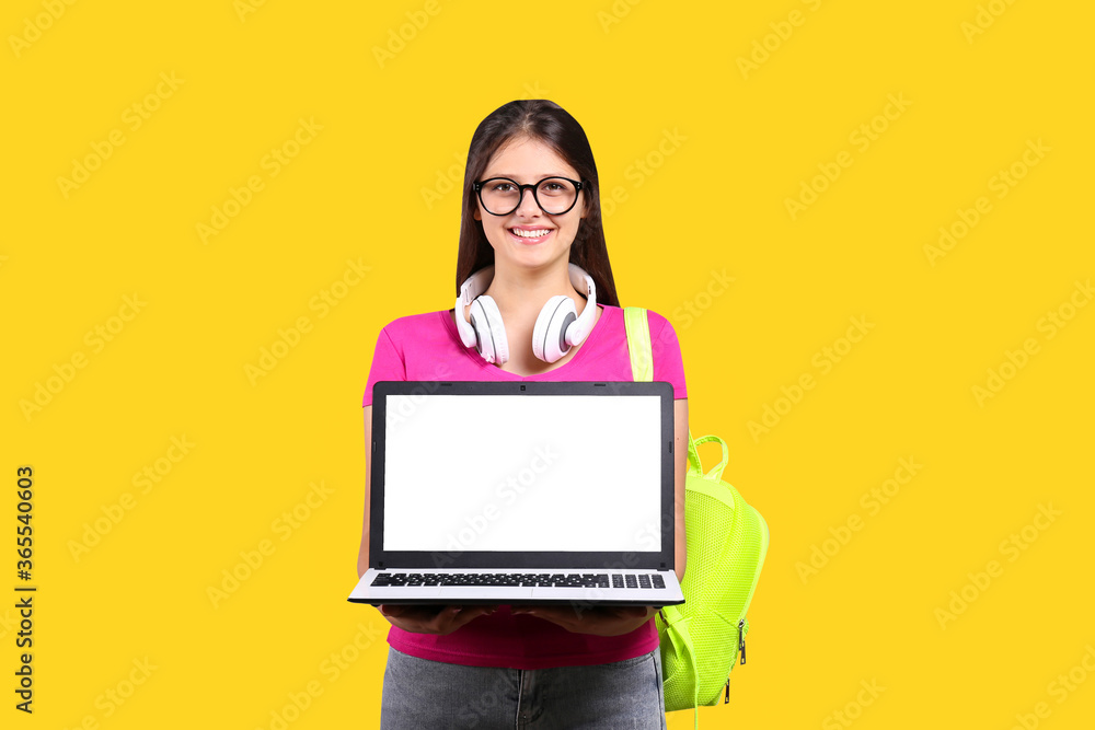 Young beautiful curvaceous woman with laptop posing over bright wall background with a lot of copy space for text. Portrait of attractive female with long brunette hair wearing pink t-shirt. Young beautiful curvaceous woman with laptop posing over bright wall background with a lot of copy space for text. Portrait of attractive female with long brunette hair wearing pink t-shirt.
