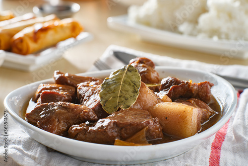 filipino pork adobo in bowl with rice in background