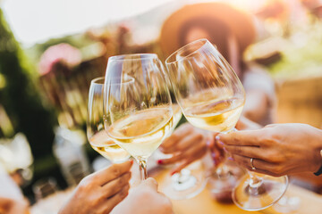 People clinking glasses with wine on the summer terrace of cafe or restaurant