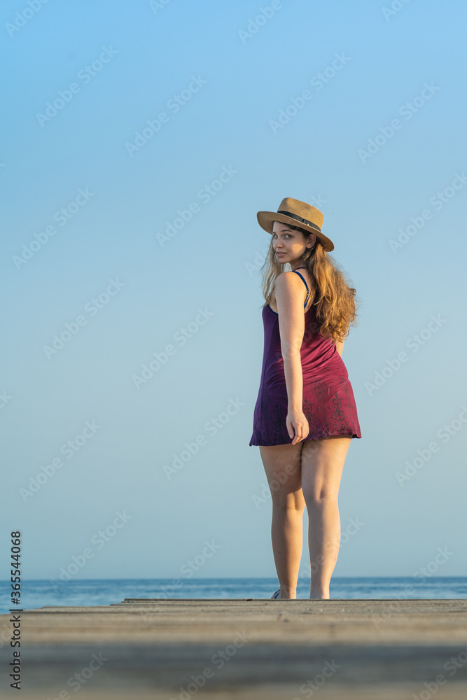 Long Blonde hair woman walking alone at the beach during sunset