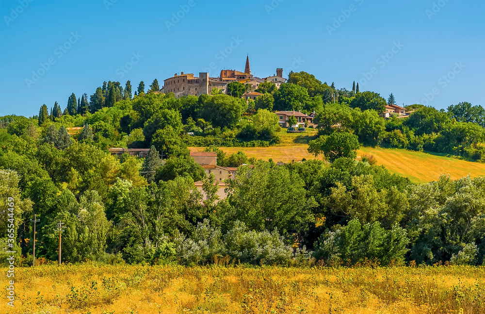 The hill top village of  Collazzone near Todi, Italy peeks out above the trees in the summertime