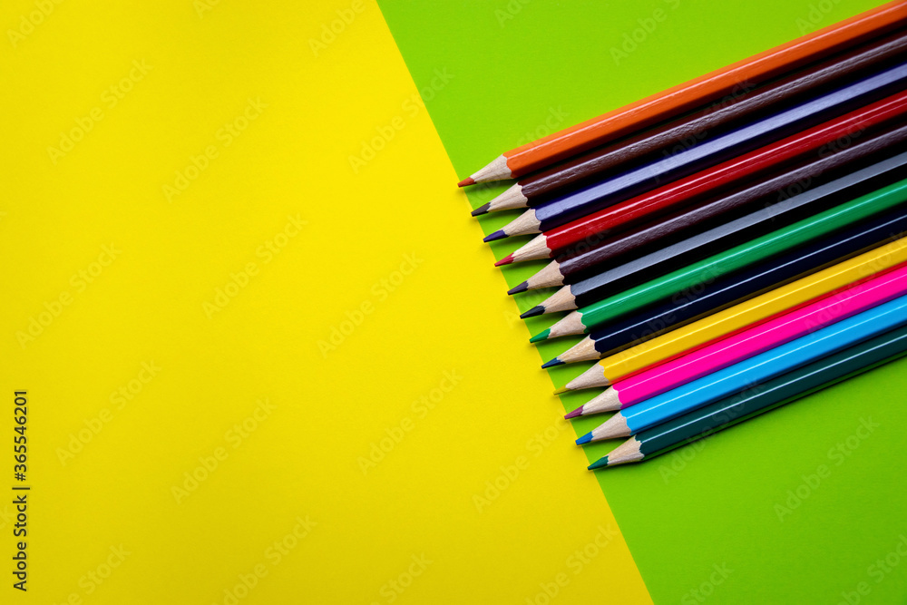 Line multicolored wooden pencils isolated on yellow-green background with copy space. Colored wooden crayons. Concept of art, education Line multicolored wooden pencils isolated on yellow-green background with copy space. Colored wooden crayons. Concept of art, education