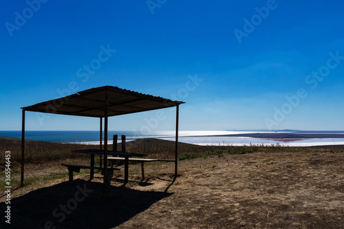 wooden gazebo in a field on the background of the lake and sea in Crimea