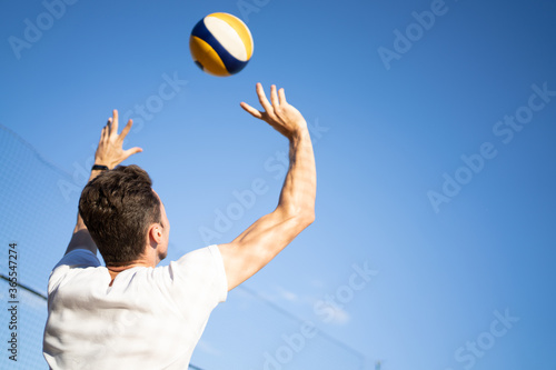 guy plays with volleyball with ball. Ball in the air