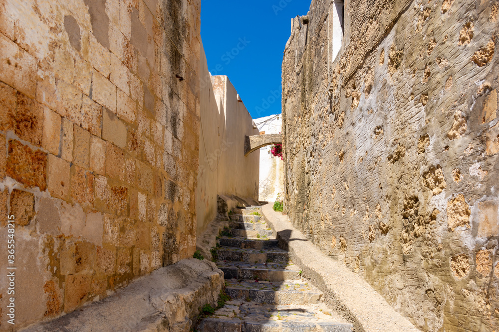 Old narrow street in Lindos village on Rhodes island. Dodecanese, Greece. Old narrow street in Lindos village on Rhodes island. Dodecanese, Greece.
