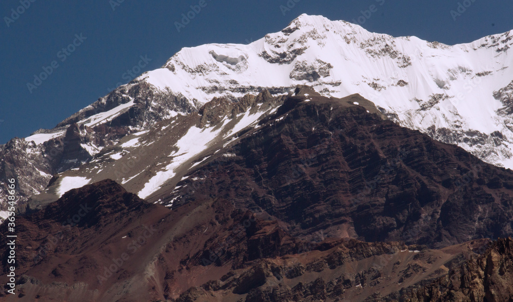 Seven summits. Mountaineering. Closeup view of the snowy and rocky peak of mountain Aconcagua, highest peak in America.