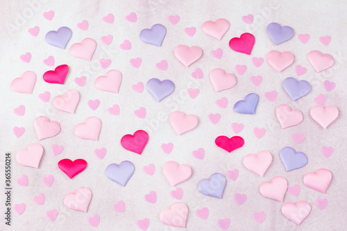 on a pink background colored hearts from satin
