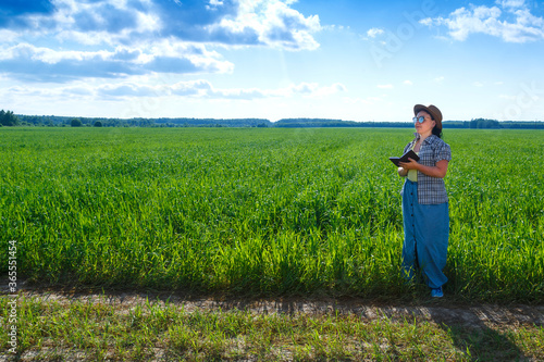 Female agronomist engineer in the field checking crops.