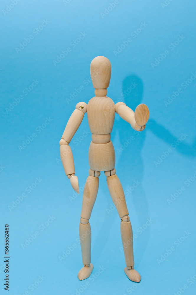 wooden figurine of a man on a colored background, holds an inscription, a coin wooden figurine of a man on a colored background, holds an inscription, a coin