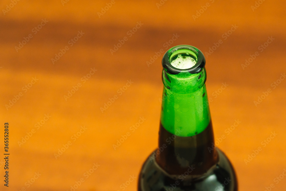 A bottle of cold dark beer on a brown background. Beer concept