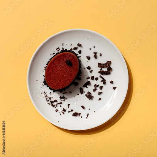 A piece of black chocolate cake with nuts and cappuccino in hard light on colorful yellow background. delicious chocolate dessert, Hard shadow, flat lay style. Food concept. Top view.