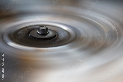 circle with a bolt head on the metal blades of a rotating fan.