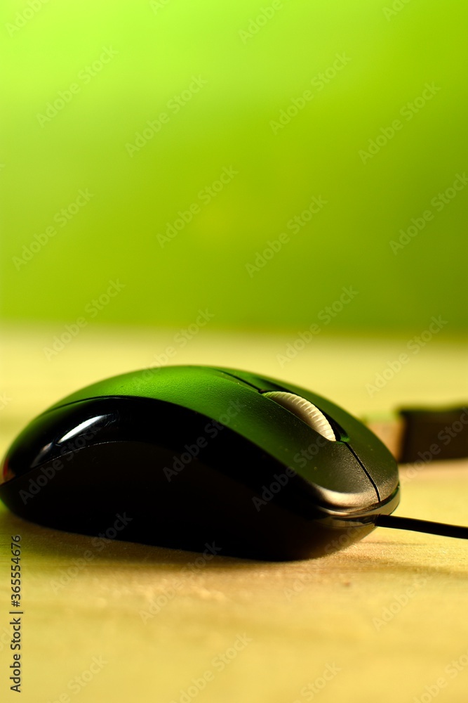 computer mouse placed on wood, diffuse green background computer mouse placed on wood, diffuse green background