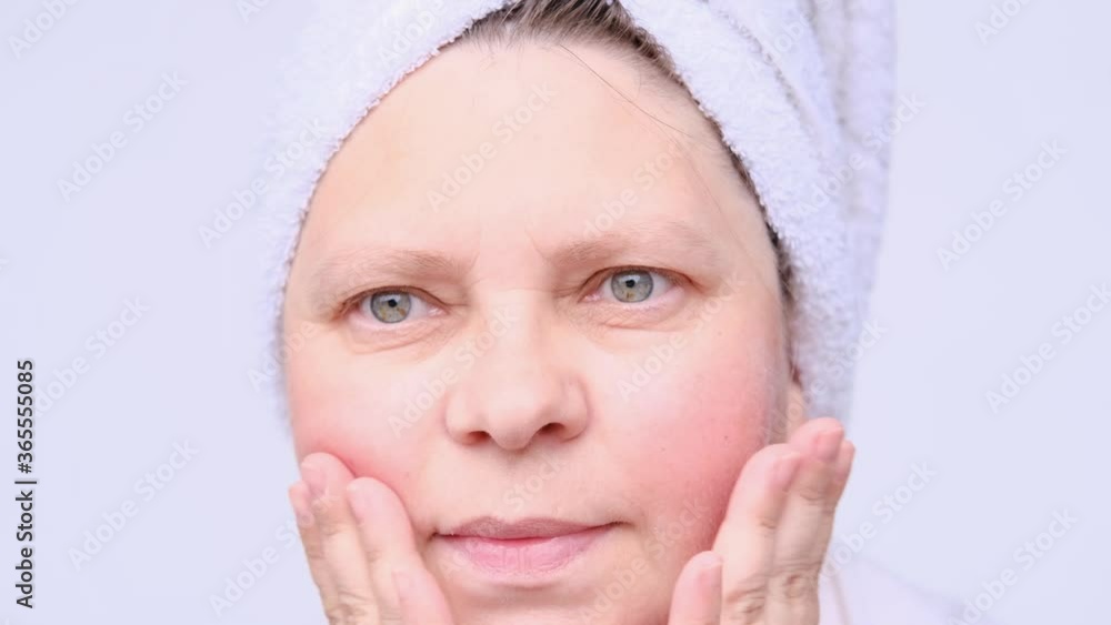 woman in adulthood, with wrinkles, makes herself a facial massage, taps her fingers, the concept of cosmetology, woman's health, natural cosmetics for aging skin care woman in adulthood, with wrinkles, makes herself a facial massage, taps her fingers, the concept of cosmetology, woman's health, natural cosmetics for aging skin care