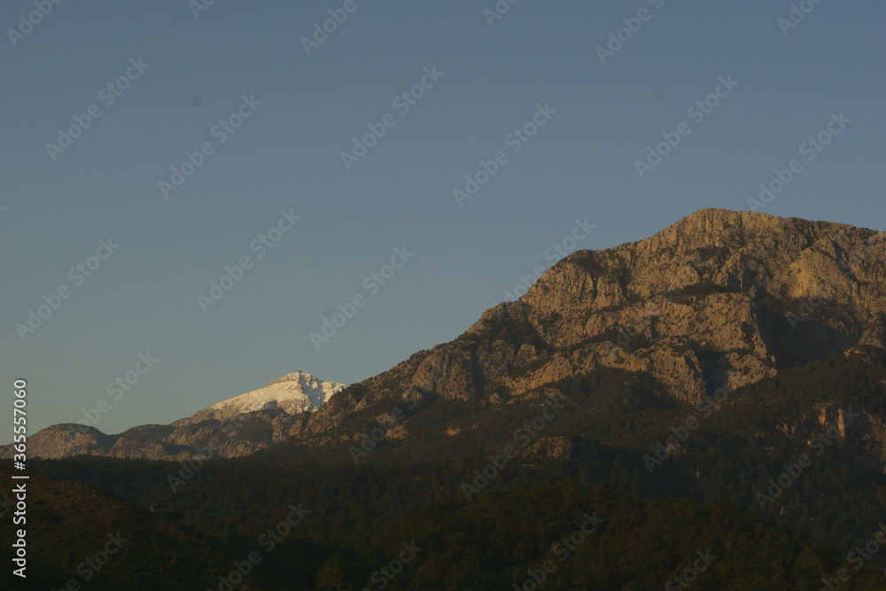 Naklejka premium View of the mountain peaks covered with snow in sunrise