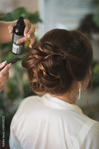 Master stylist makes the bride wedding hairstyle using spray lacquer fixing