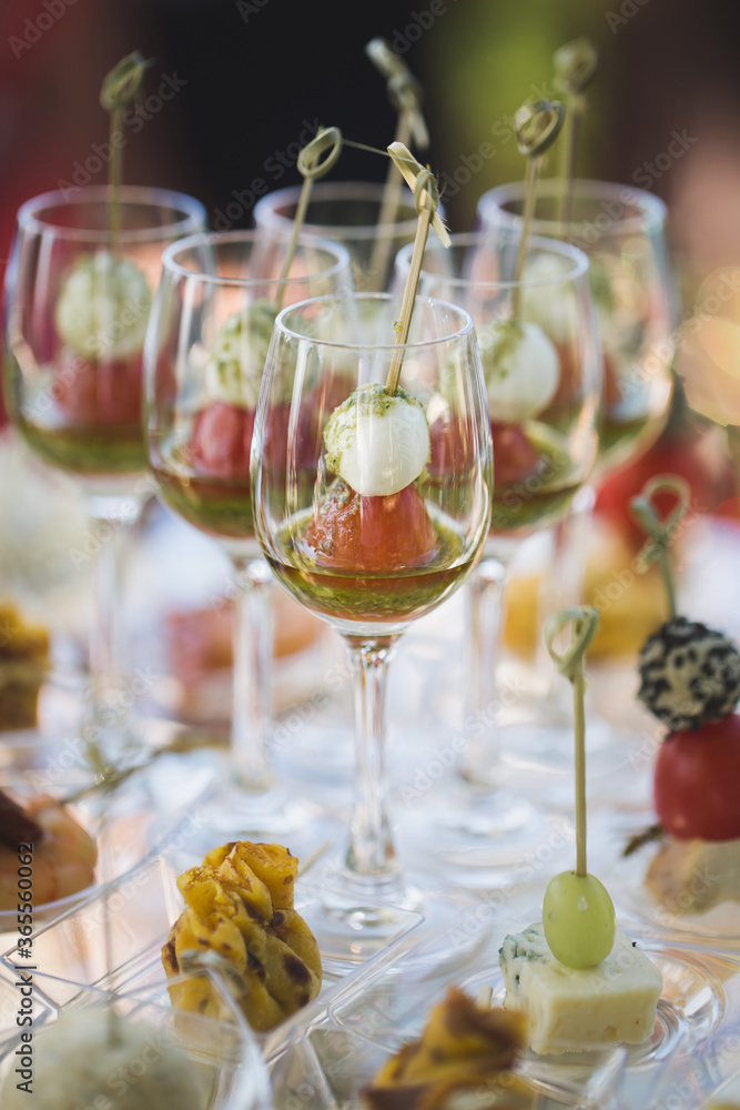 Reception at the wedding. Snacks and wine glasses on a glass table.