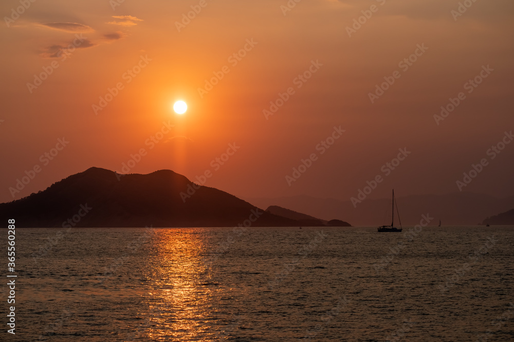 Boat at sea while sun sets
