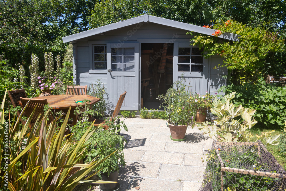 Shed with terrace and garden furniture in a garden during summer