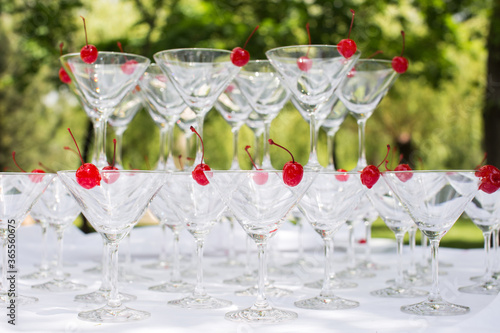 Close-up of the champagne pyramid with a red cherry at the top of each glassGlass goblets. Pyramid of champagne. A celebratory drink. Decorations for the Banquet. photo