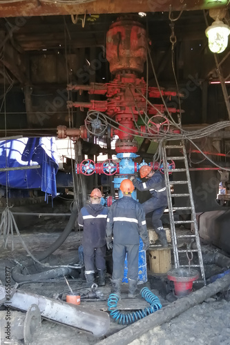 Drilling crews are installing equipment to prevent the release of oil and gas while drilling a well. Red BOPs are installed at the wellhead.