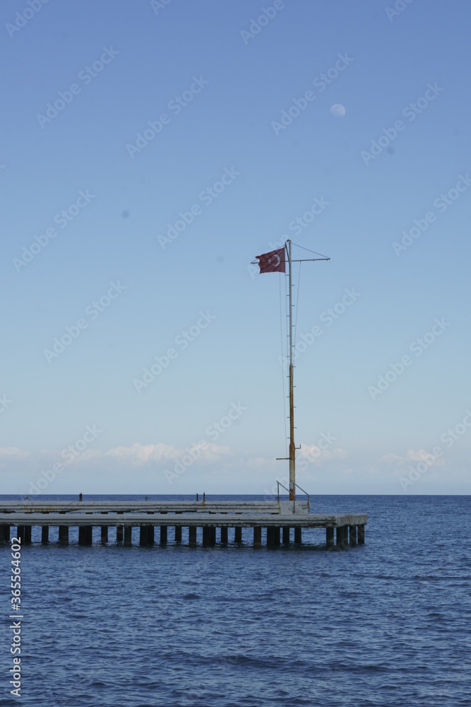 Turkish flag on flag pole over the empty pier