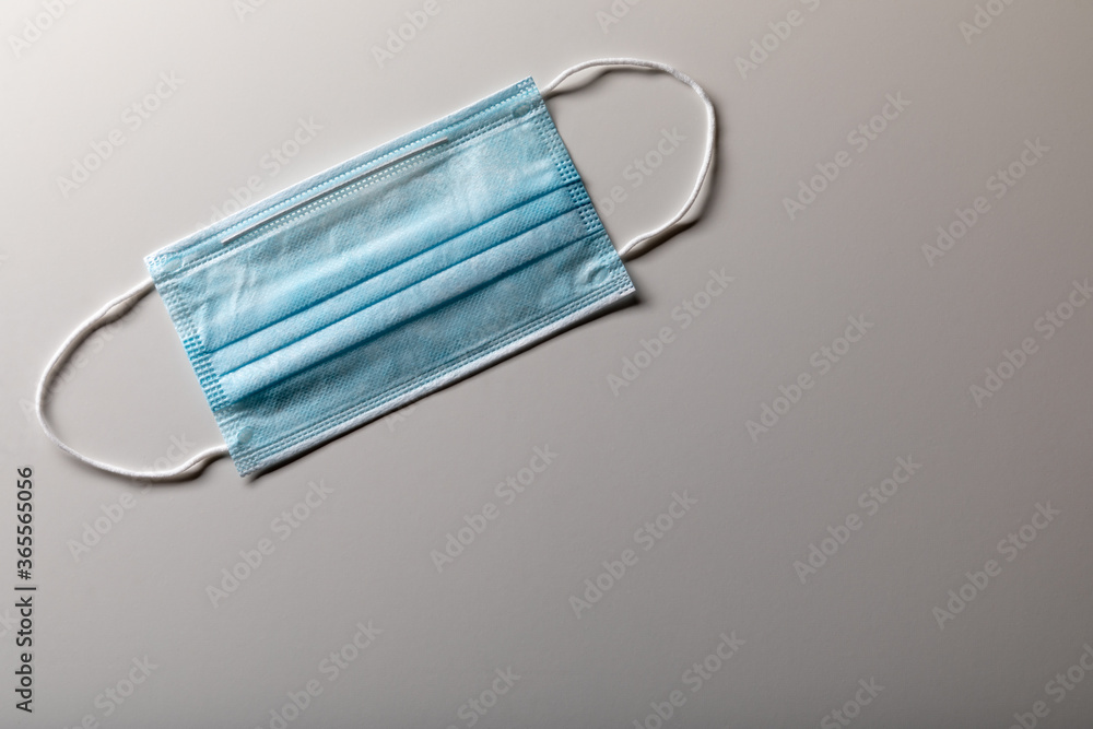 Single Medical Face Mask Resting on Gradated Surface Single Medical Face Mask Resting on Gradated Surface