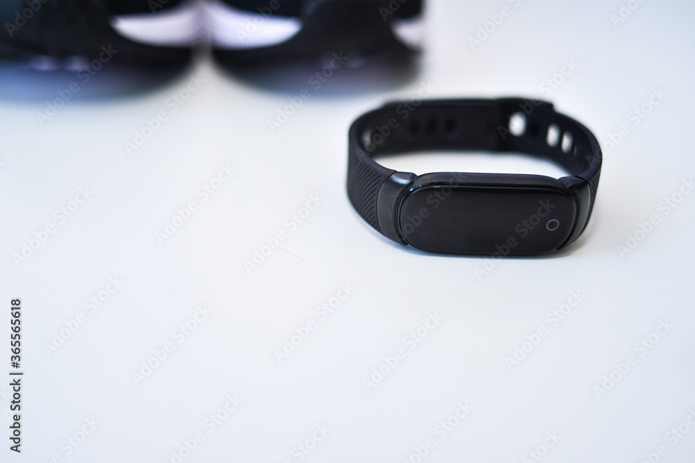 Sports black shoes and watches for monitoring your health on a white background Sports black shoes and watches for monitoring your health on a white background