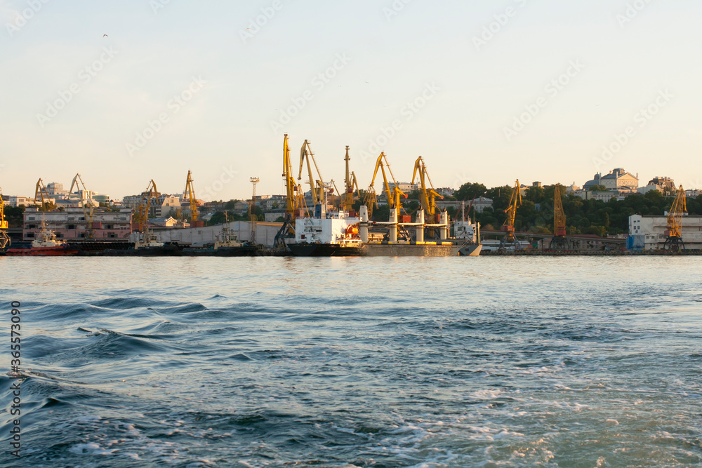 Portal cranes in the evening port in Odessa, Black Sea. Waves at sea