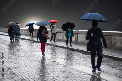 People with umbrellas on gloomy rainy day