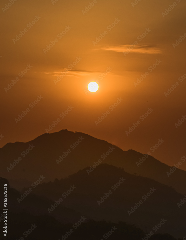 Sol saliendo sobre las montañas durante el amanecer. Paisaje de siluetas de montañas durante la hora dorada. 