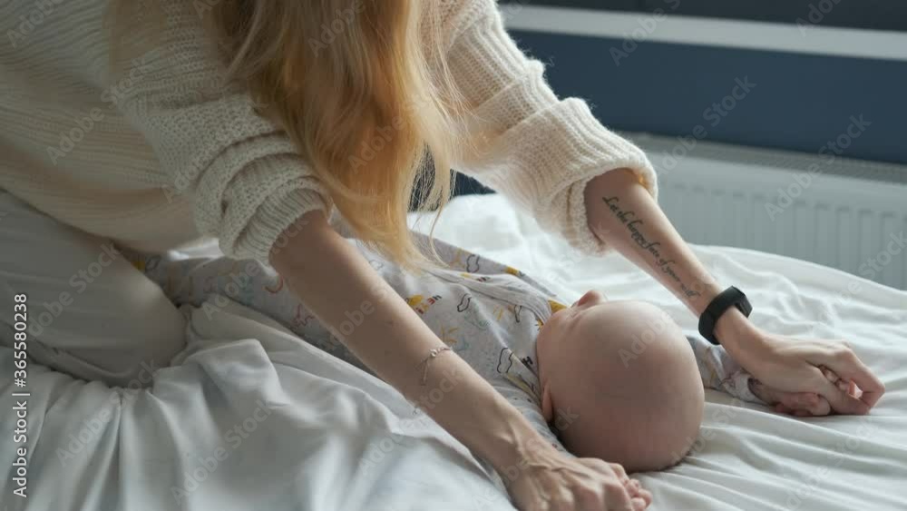 mom does hand massage to baby on bed mom does hand massage to baby on bed