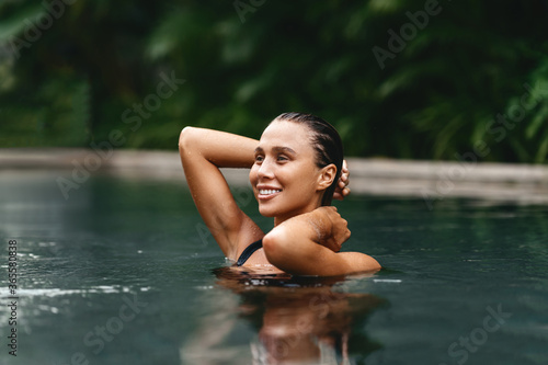 Retreat and vacation. Beautiful young woman relaxing in spa swimming pool.