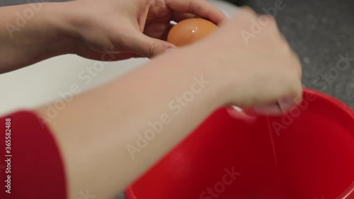 Young woman's hands braking eggs