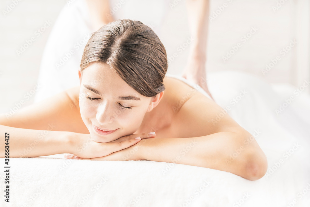 明るい雰囲気のエステサロンでマッサージを受ける若い女性 明るい雰囲気のエステサロンでマッサージを受ける若い女性