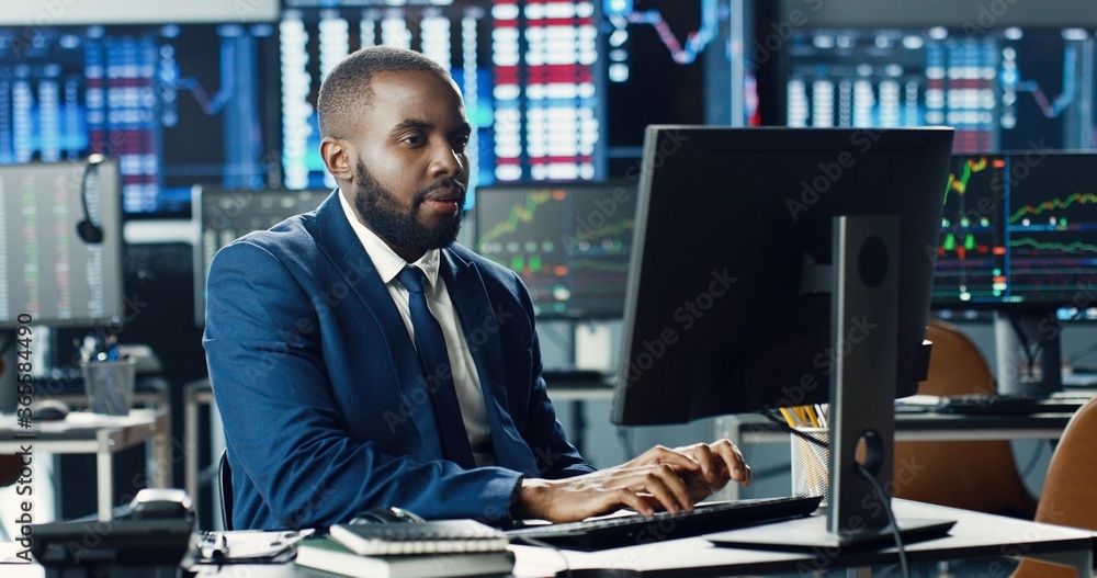 African american male stock trader or broker working at stock exchange